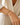 A woman wearing a light blue and gold beaded bracelet