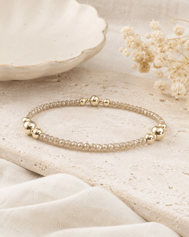 A gold and champagne shimmer beaded bracelet on a table
