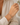 A delicate beaded bracelet with light blue and gold beads worn on a woman's wrist, shown in a close-up lifestyle shot against a soft cream-colored blouse.