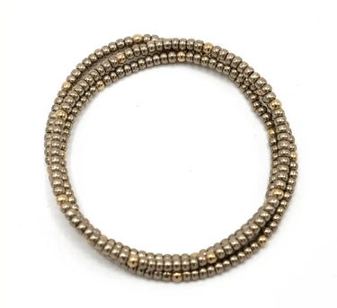 A bronze and gold beaded bracelet stack on a white background