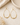 Gold beaded teardrop Earrings on a table