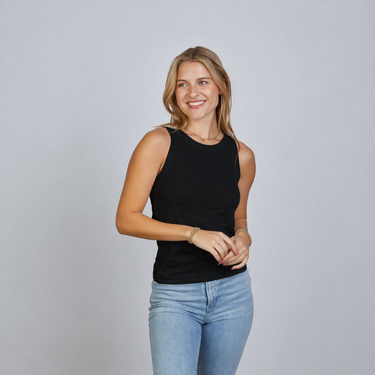 a woman wearing a high neck black tank and blue jeans