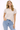 Woman wearing a beige t-shirt and light blue jeans on a white background