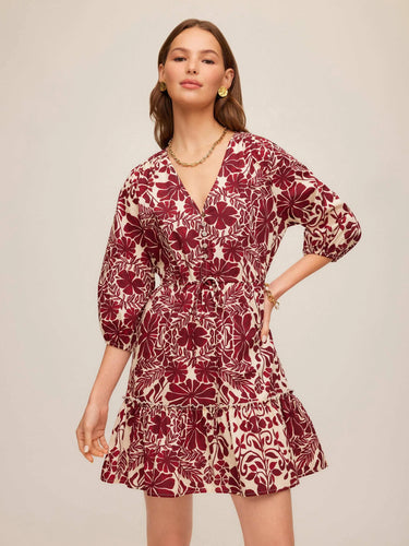 Woman wearing a red floral dress on a beige background