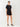 Woman wearing a black romper with buttons on a white background