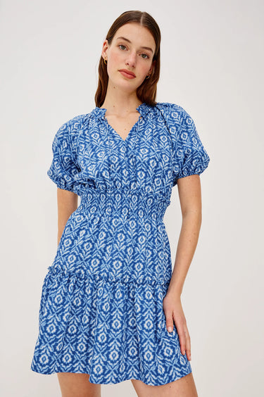 Woman wearing a blue patterned dress on a white background
