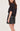 A woman facing backwards wearing a black tee, faux leather skirt in black on a white background.