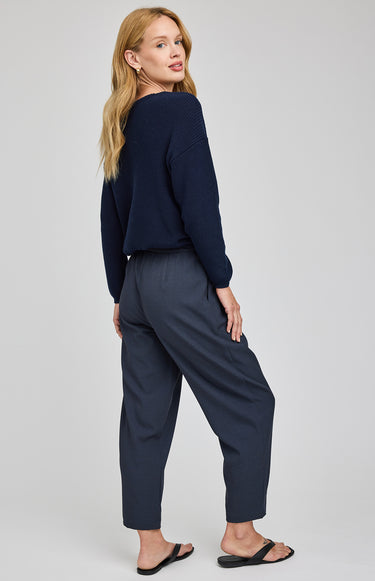 Woman wearing a navy blue outfit on a plain background