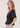 A woman wearing a v neck poplin top with ruching at the center on a white background