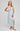 Woman wearing a light blue dress with a white background