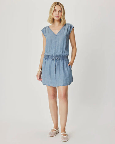 A women wearing a light blue cotton denim dress with an adjustable waistband