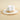 White straw hat with a beige band on a beige background