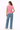 Woman wearing a pink t-shirt and blue jeans on a white background