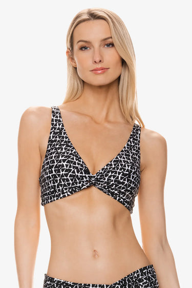 Woman wearing a black and white patterned bikini top on a white background