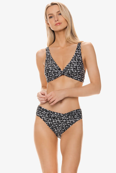 Woman wearing a black and white patterned bikini on a white background