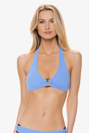 A woman wearing a textured halter swim top on a white background