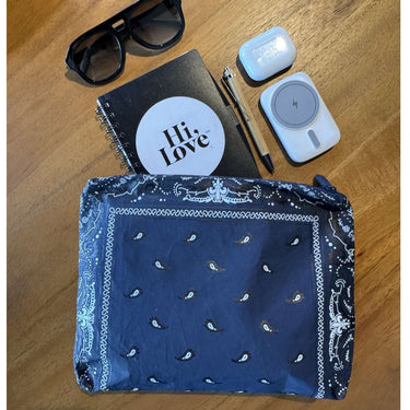 a medium navy bandana printed zipper pouch on a wooden table