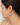 A close-up side profile of a woman wearing a gold hoop earring with a semi-circular light gray and white marbled stone insert.