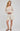 Woman wearing a beige sweater and striped shorts on a white background