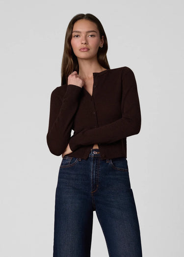 a woman wearing a dark brown cardigan and dark blue jeans on a white background