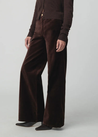 Chocolate brown button-front cardigan styled with matching wide-leg velvet pants and pointed-toe shoes on a model.