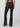 Black slim bootcut jeans styled with a metallic silver top and pointed-toe black heels on a model.