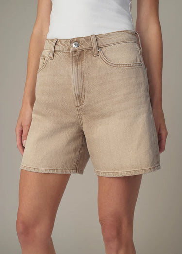 A woman wearing relaxed fit denim shorts in tan