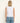 Person wearing a white sleeveless top and blue jeans on a plain background