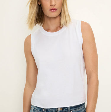 Woman wearing a white sleeveless top against a plain background