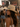 Woman wearing a straw hat at a music festival with stage lights in the background