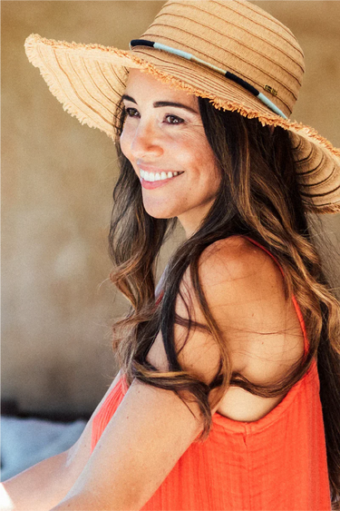 A woman wearing a natural wide brim sun hat
