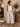A woman wearing beige cropped wide leg pants in a store