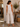 A woman wearing beige cropped wide leg pants in a store