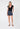 Woman wearing a black top and denim shorts on a white background