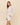 Woman wearing a white linen outfit on a beige background
