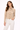 Woman wearing a beige jacket and white pants on a white background