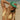A woman on a beach wearing a green mesh-back trucker hat with a colorful 'Super Sweet March' patch on the front, paired with a pale yellow bikini top.