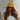 Woman wearing a yellow cap with a logo against a stone wall background