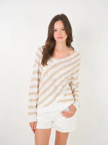 A woman wearing a knit beige and white striped sweater