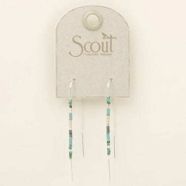 A pair of long beaded dangle earrings displayed on a light gray Scout Curated Wear card. The earrings feature turquoise, black, and cream beads with silver-toned metal wire ends.