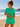 Woman in green outfit standing on a beach with ocean view