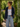 Woman standing in a garden wearing a navy hoodie, white tank top, and light blue jeans.