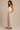 a woman wearing beige colored pleated pants and a white tank