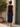 Woman wearing a navy blue dress standing in front of a white wall and green door.