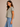 a woman wearing a crewneck cropped boxy fit tee in pale army green with jeans on a neutral background