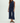Woman wearing a navy blue sleeveless top and wide-leg pants on a white background