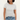 A woman wearing a light gray short-sleeve crewneck t-shirt and blue jeans, standing against a plain off-white background.