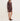 A woman models a ribbed knit mini dress in a dusty rose-brown color, paired with matching pointed-toe heels, against a plain off-white studio background.