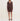 A woman modeling a ribbed knit long-sleeve mini dress in a dark brownish-purple color, paired with matching pointed-toe heels, against a plain off-white studio background.