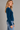 a woman wearing a brushed yarn crewneck sweater in a deep blue and blue jeans